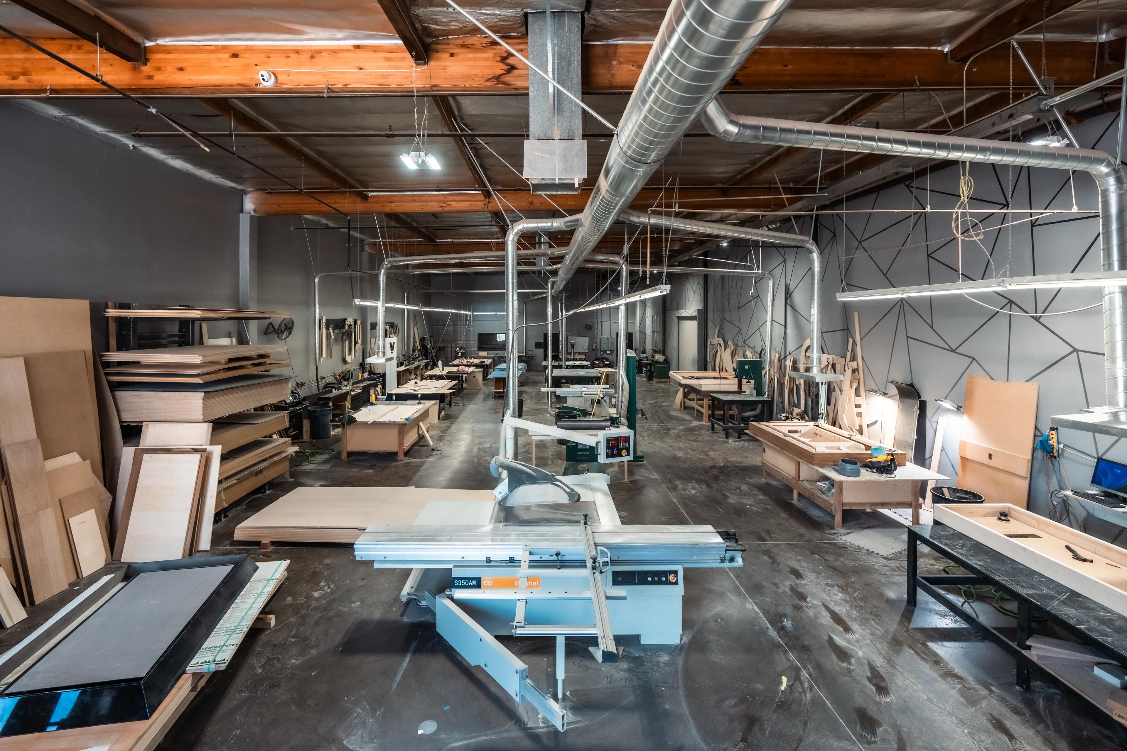 Elevate Customs woodworking floor in Los Angeles — machinery, benches, and dust collection under one roof